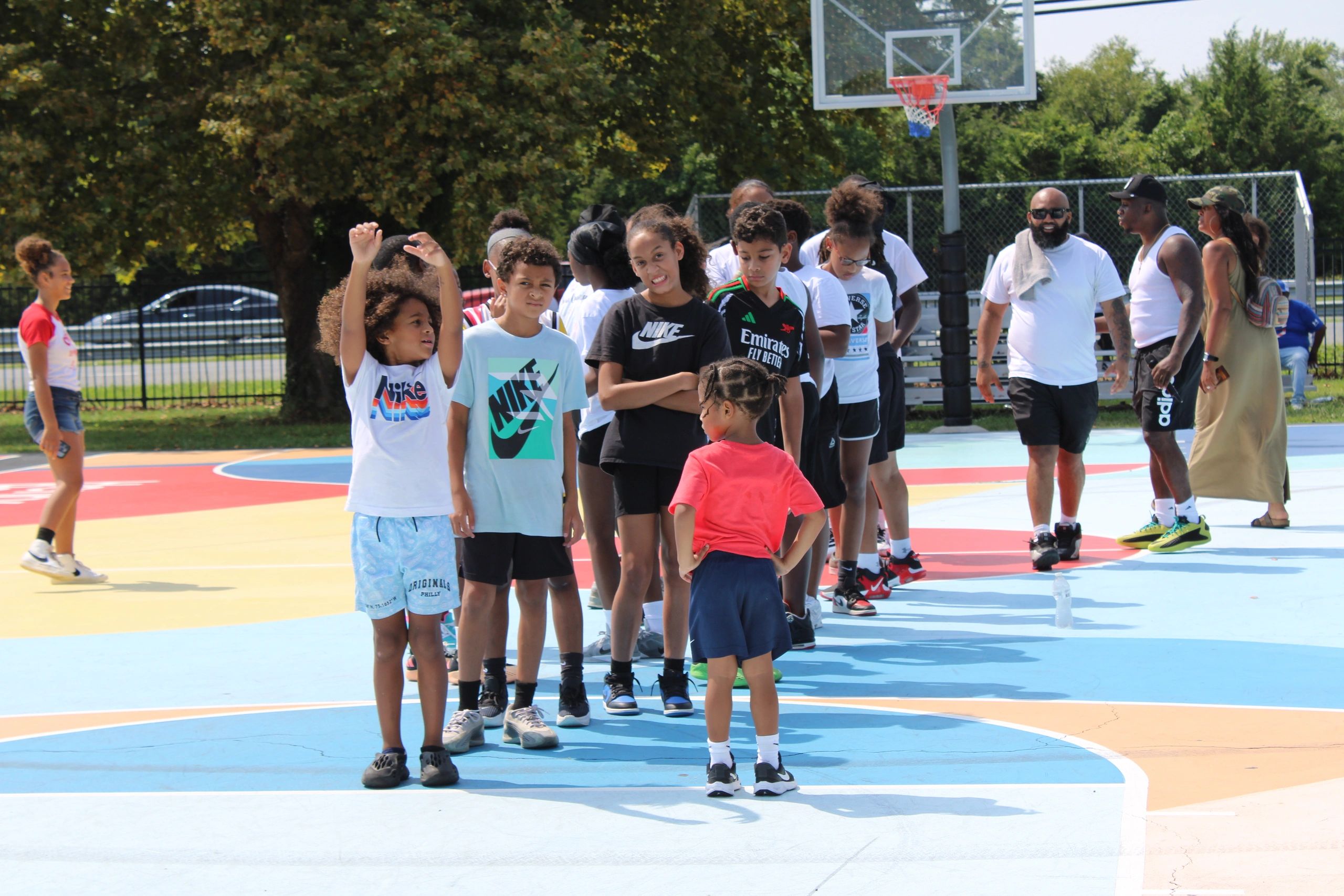 Youth and community members on a colorful basketball court at a Driven Over Given event
